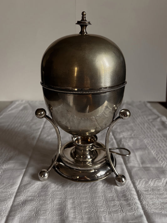 Antique silver-plated egg coddler with a domed lid, ornate warming stand, and a polished finish, perfect for elegant dining